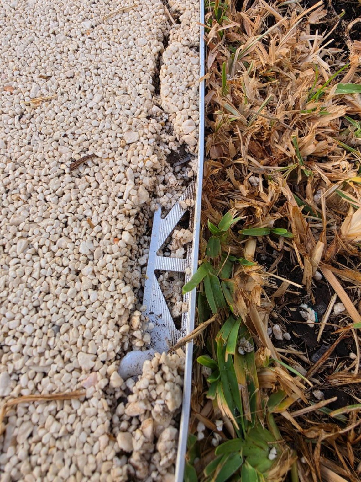 Loose aggregate and exposed edging on a failed resin bound surface